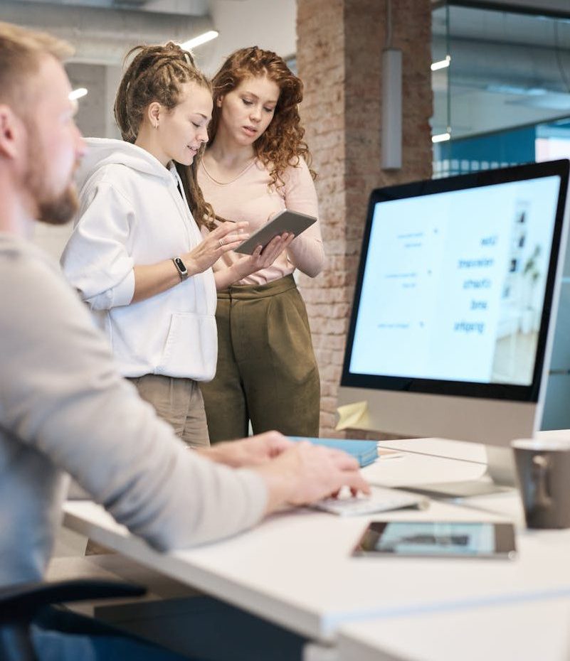 Young professionals collaborating in a modern office setting with digital devices.